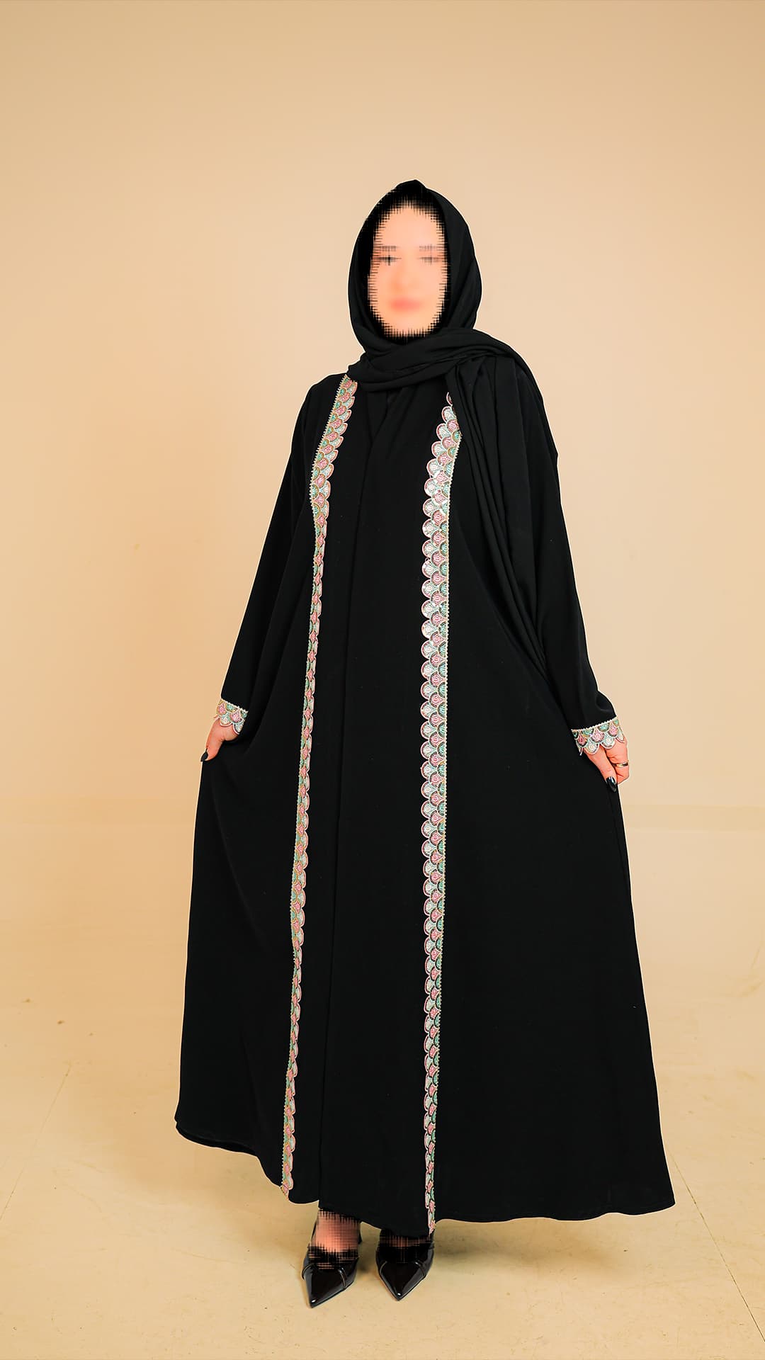 Original product photography for Rilam showing a black abaya with silver trim against a plain studio background.